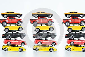 Multiple car toys on top of each other suggesting automotive industry problems