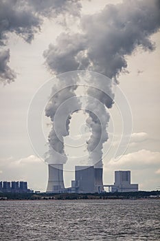 Multiple coal fossil fuel power plant smokestacks emit carbon