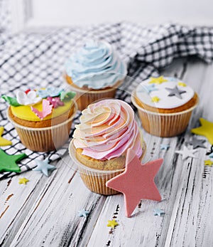 Multiple colorful nicely decorated muffins on a wooden