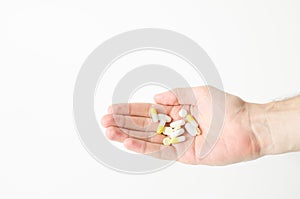 Multiple colors pills in hand on white background, Taking Your Medication.