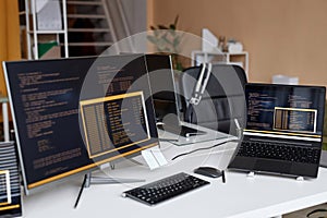 Multiple Computer Devices with Code Lines on Screen in IT Development Office