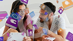 Multiple digital icons floating against man and woman using digital tablet and smartphone at home