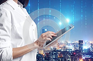 Multiple exposure of female programmer with tablet, digital binary code and night city.
