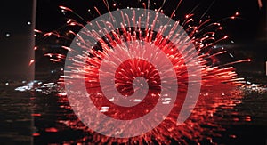 Multiple fireworks in a composition in shades of red, reflecting in water.