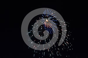 Multiple fireworks exploding in a dance of light bright blue streaks and falling light blue sparkling light show