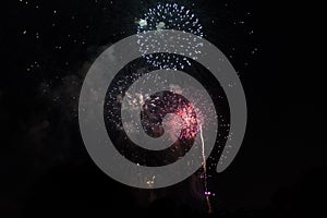 Multiple Fireworks in night sky in a composition in shades red and white