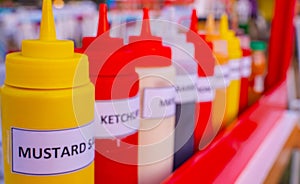 Multiple flavor sauce bottles in a food card at a food festival. Different sauces in plastic