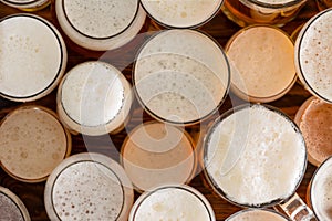 Multiple full, frothy beer glasses and sizes