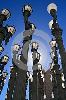 Multiple historic street lights stand in a pattern