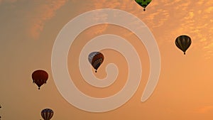 Multiple Hot Air Balloons Floating By at Different Highs on a Golden Early Morning Launch