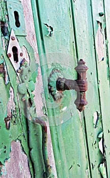Multiple keyholes and a rusty vintage door handle closeup