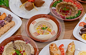 Multiple lebanese appetizers and salads togeather on the table. focused on hummus