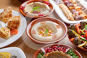 Multiple lebanese appetizers and salads togeather on the table. focused on hummus