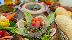 Multiple lebanese appetizers and salads together on the table. focused on tabbouleh