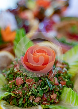 Multiple lebanese appetizers and salads together on the table. focused on tabbouleh