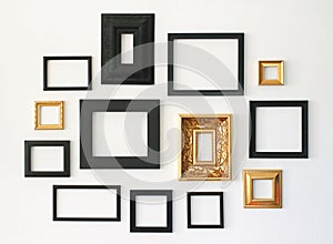 Multiple many blank small picture frames on white wall photo