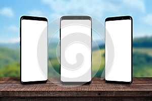 Multiple mobile phones on wooden desk for product, app presentation
