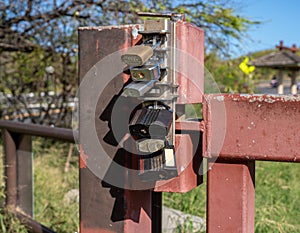 Multiple padlocks on a steel gate to securely lock it