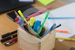 Multiple pens There are different colours. Put it in a wooden box on the desk which is full of documents and has a phone