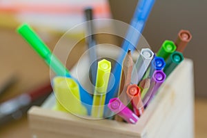 Multiple pens There are different colours. Put it in a wooden box on the desk which is full of documents and has a phone