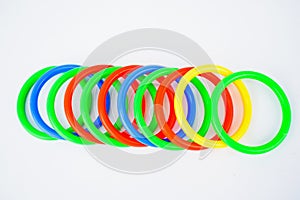 Multiple plastic circle shaped toys arranged on an isolated white background