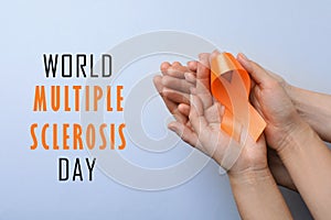 Multiple Sclerosis Awareness Day. People with orange ribbon on light background, top view