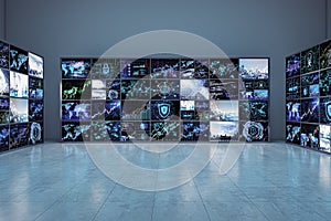 Multiple screens displaying various graphs and data visualizations in a room with a grey background