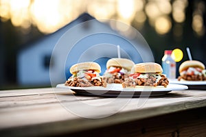 multiple sloppy joes on a picnic table, outdoor light