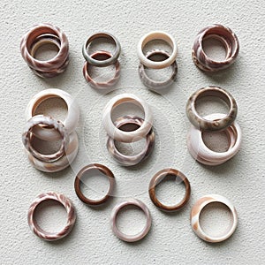 Multiple stone rings are arranged on a textured light grey surface
