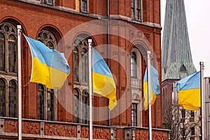 Multiple ukrainian flags waving in front of Rotes Rathaus builidng, Berlin city hall, representing support, political unity, photo