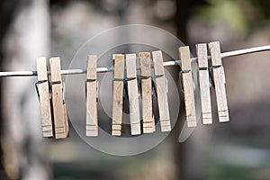 Multiple Wooden Clothespins Hanging from Cable