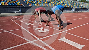 Multiracial athletes in starting position, ready to run after command, marathon