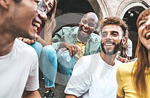 Multiracial best friends laughing together hanging out on city street