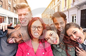 Multiracial best friends taking selfie outdoors in urban contest - Happy young people having fun together - Multi ethnic and