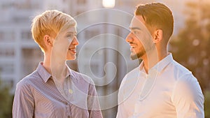 Multiracial business colleague couple arabic hispanic man and mature caucasian woman standing outdoors in sunlight