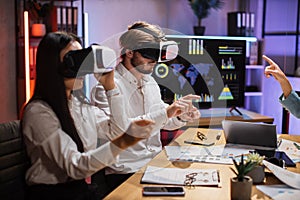 Multiracial business colleagues wearing VR goggles at office