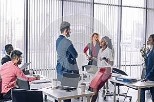 Multiracial business coworkers talking, interacting on workplaces