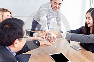 Multiracial business people collapse stacking hands over work table in modern meeting room.Teamwork join hands support together in