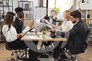 Multiracial business people in formal wear having meeting