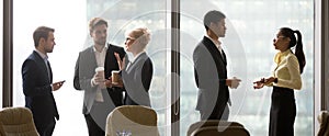 Multiracial, business people talking in break, standing near win