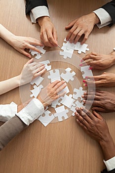 Multiracial business team assembling puzzle together, vertical c