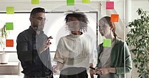 Multiracial business team brainstorm drawing on glass at business meeting