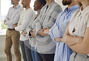 Multiracial business team standing in row joining their hands
