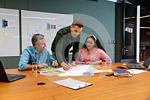 Multiracial businessmen and businesswoman discussing strategy in meeting at creative office