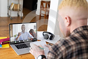 Multiracial businessmen planning strategies while video conferencing through laptop in office