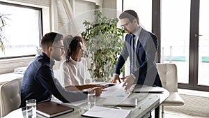 Multiracial businesspeople brainstorm discuss paperwork in office