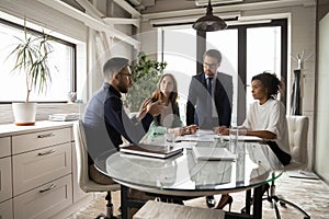 Multiracial businesspeople brainstorm at team briefing in office