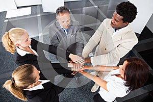 Multiracial businesspeople stacking hands