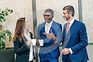 Multiracial businesspeople talking during coffee break