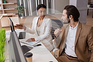 multiracial businesswoman pointing at computer monitor
